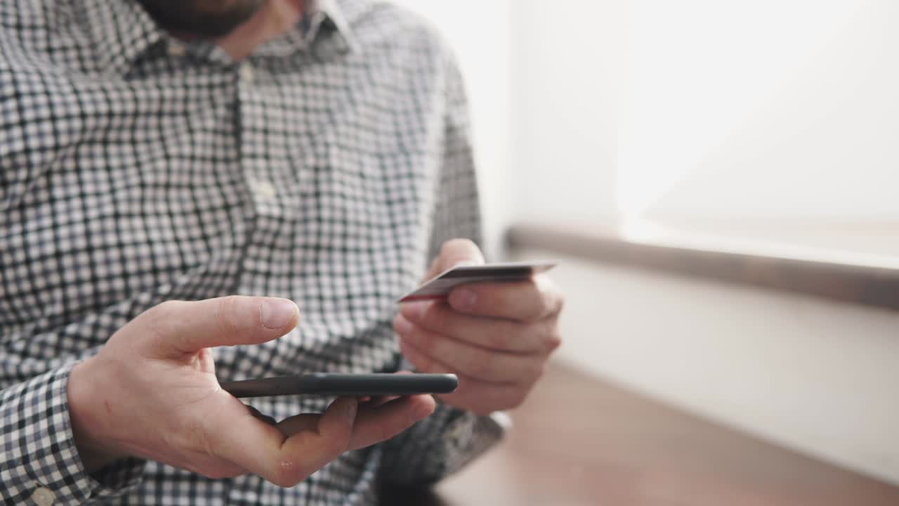 fotografía de cerca de las manos de un hombre, que está ocupado en el pago de una tasa de tarjeta en línea