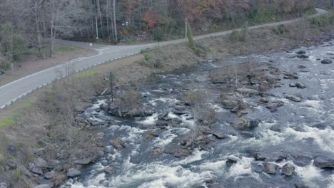 Drohnenaufnahme-Eines-Flusses-Und-Einer-Straße-In-Geringer-Höhe,-Der-Im-Spätherbst-Im-Westen-Von-North-Carolina-Nach-Oben-Und-Rechts-Schwenkt