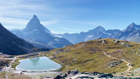 vrijheid: matterhorn berglandschap bij rotenboden en gornergart, zwitserland, europa | beweging over ruig landschap bij rotssculpturen boven reispaar in de verte, wandelen