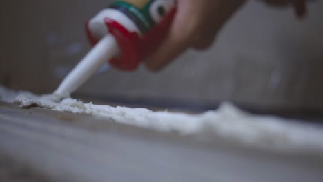 silicone sealant application with a caulking gun - close up