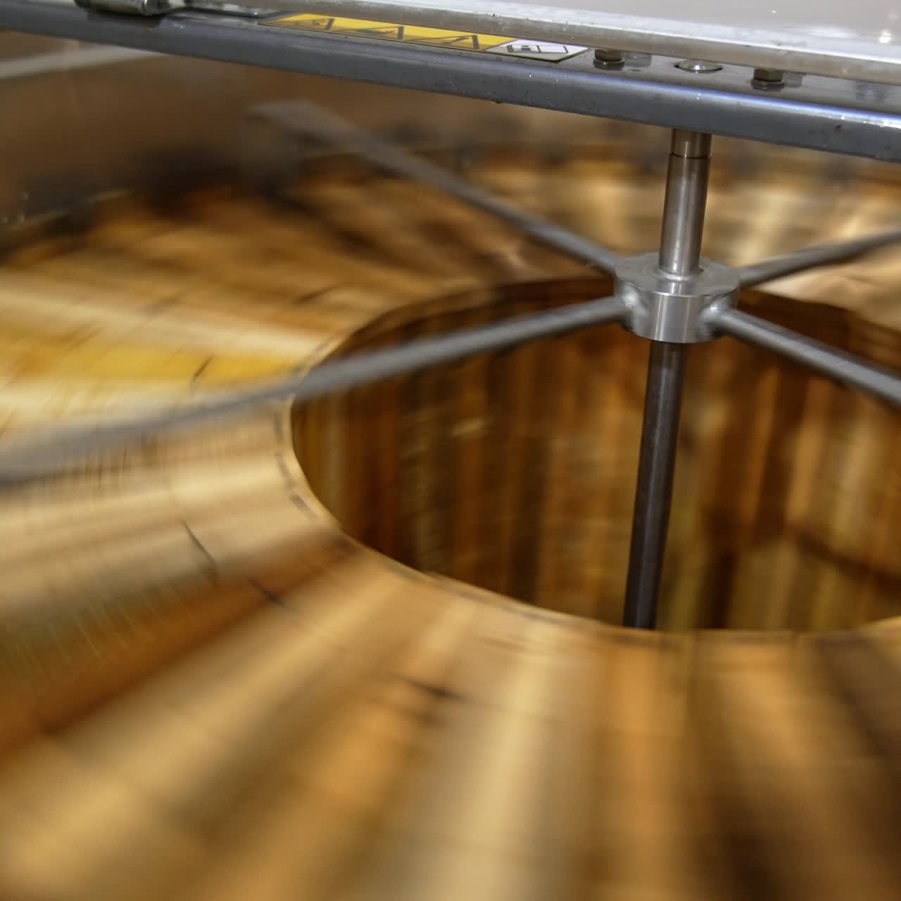 Honey frames are rotated in the centrifuge. Close up. Removal of fresh harvest of honey in the extractor machine