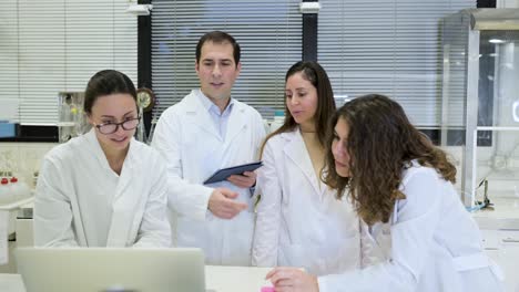 grupo de científicos discutiendo los detalles de la investigación en el laboratorio