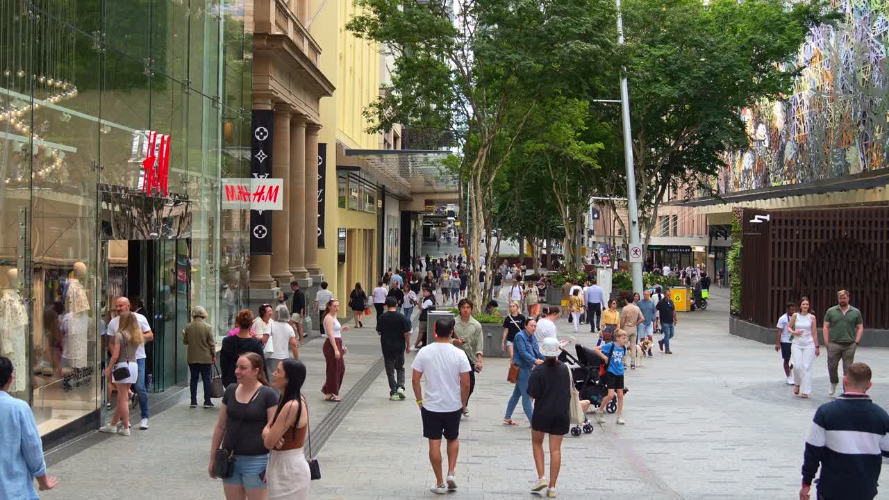 Vibrant urban environment, street scene of downtown Brisbane city, shoppers shopping at Queen street mall on the weekend, people strolling at outdoor pedestrian shopping precinct, slow motion shot.