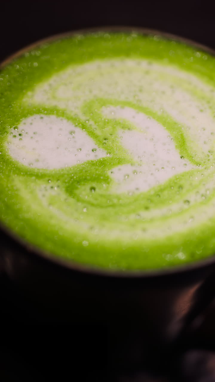 Close up of a matcha latte on a tray at a cafe. Vertical