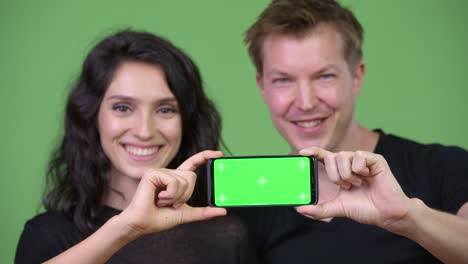 young couple showing phone together