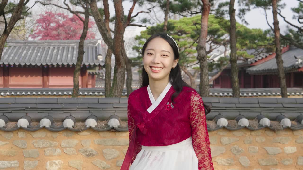 Bellissima donna coreana in hanbok rosso che si volta