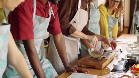 chef adding spices to bowl during cooking master class