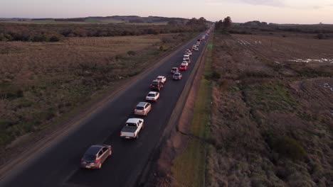 Vuelo-De-Drones-Sobre-Un-Atasco-De-Tráfico-En-Una-Ruta-Rural-Al-Atardecer-En-Uruguay,-Sudamérica