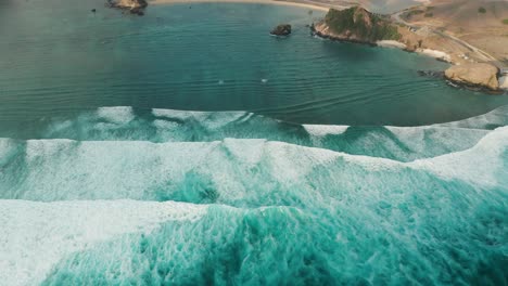 olas de aguas bravas ruedan sobre arrecifes poco profundos hacia la costa de lombok, antena