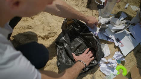 disparo recortado de jóvenes recogiendo basura en la playa