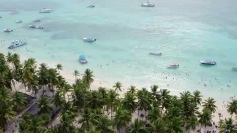 Yates-De-Lujo-Y-Multitudes-De-Turistas-Se-Reúnen-A-Lo-Largo-De-Las-Playas-De-Arena-Blanca-De-La-Isla-Saona,-Revelación-Aérea