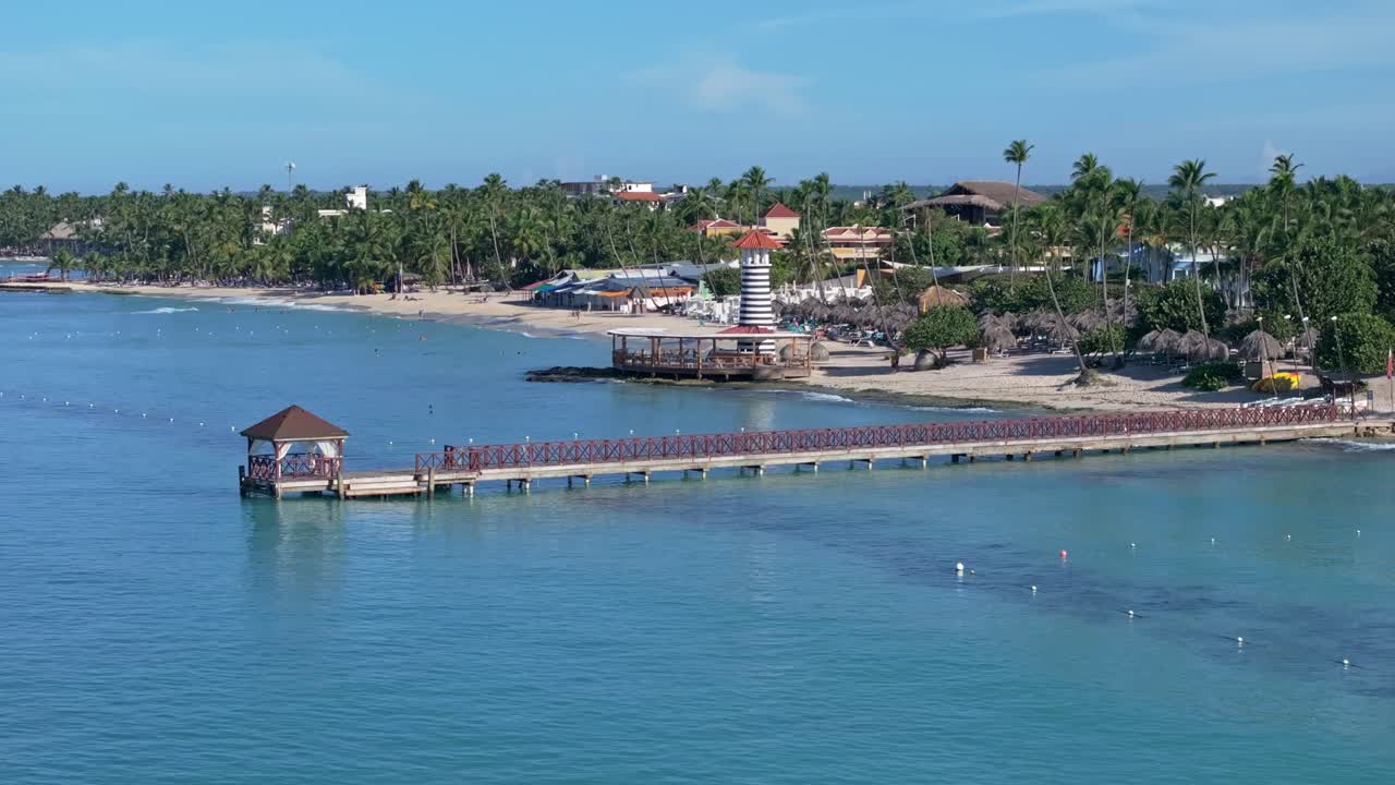 Aerial wide shot of Jetts with lighthouse at Playa Dominicus at summer sunny day. Tranquil water of Caribbean sea and palm trees on island. BAYAHIBE , Dominican Republic.