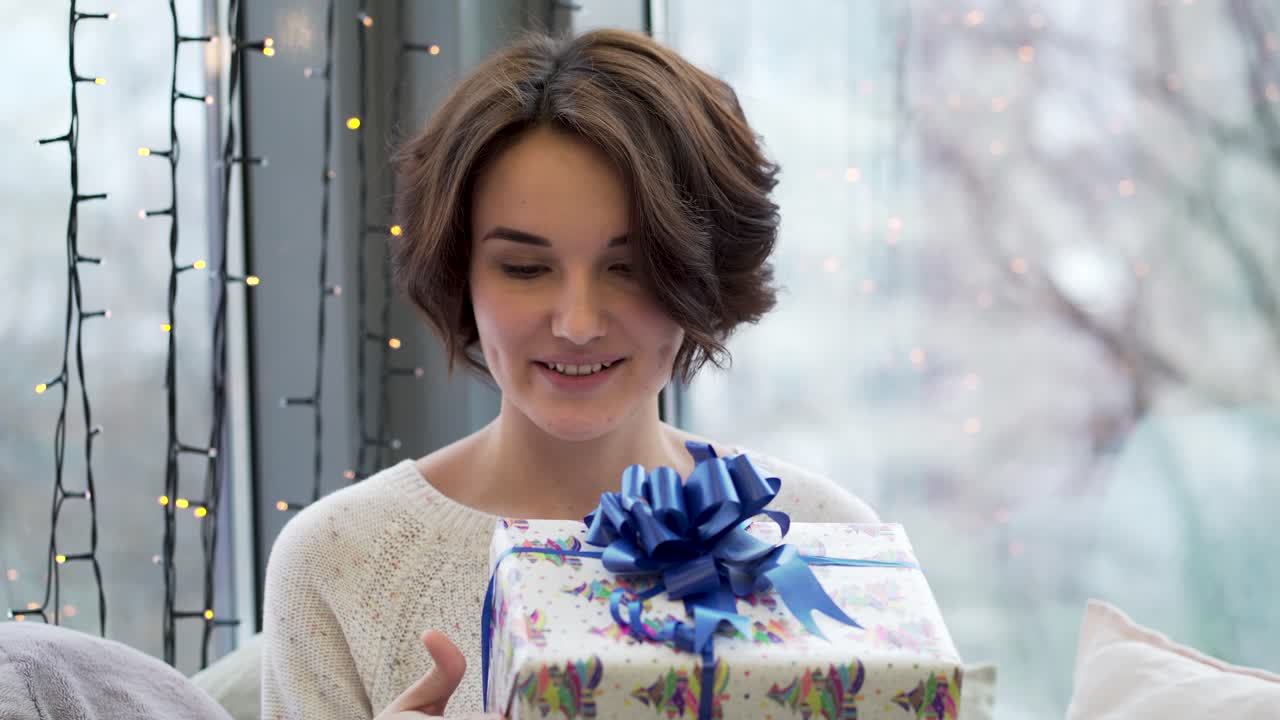 크리스마스 선물을 열고 있는 여자