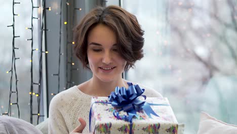 mujer abriendo un regalo de navidad