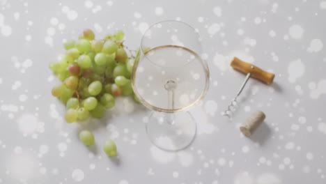 compuesto de vaso de vino blanco, uvas y sacacorchos sobre fondo de viña