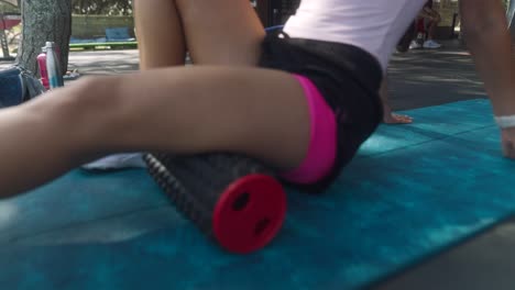 woman stretching with foam roller outdoors