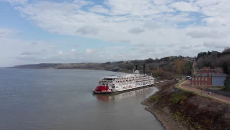 Toma-Aérea-Panorámica-Amplia-Del-Crucero-Fluvial-American-Queen-Atracado-En-El-Puerto-De-Natchez-En-Mississippi