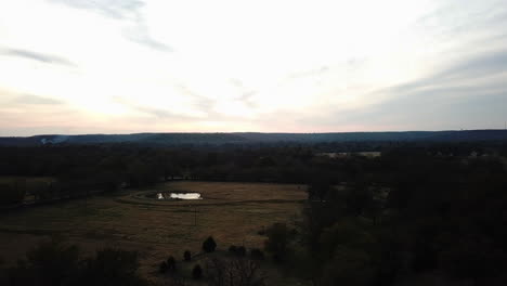 Aerial-dolly-shot-over-a-small-pond-in-a-countryside-field