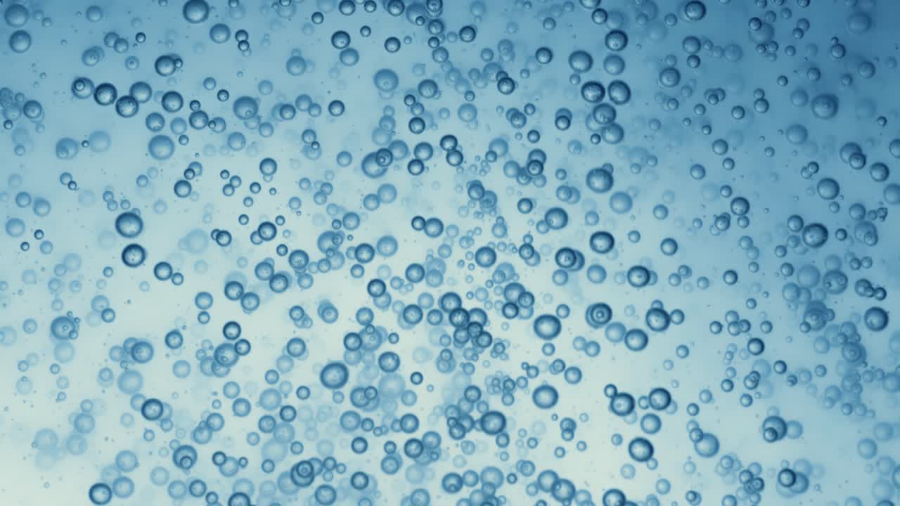 Many water bubbles in blue water close up, abstract water wave with bubbles in slow motion.