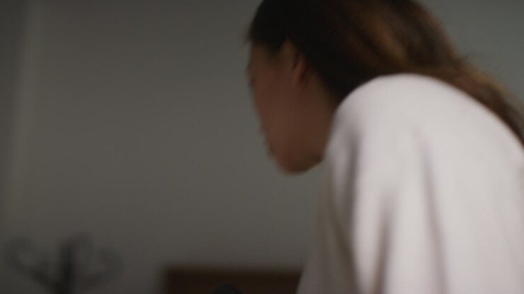 Donna arrabbiata, ansiosa o stressata a casa, in piedi nel salotto, che discute al telefono cellulare. Ripresa in tempo reale.
