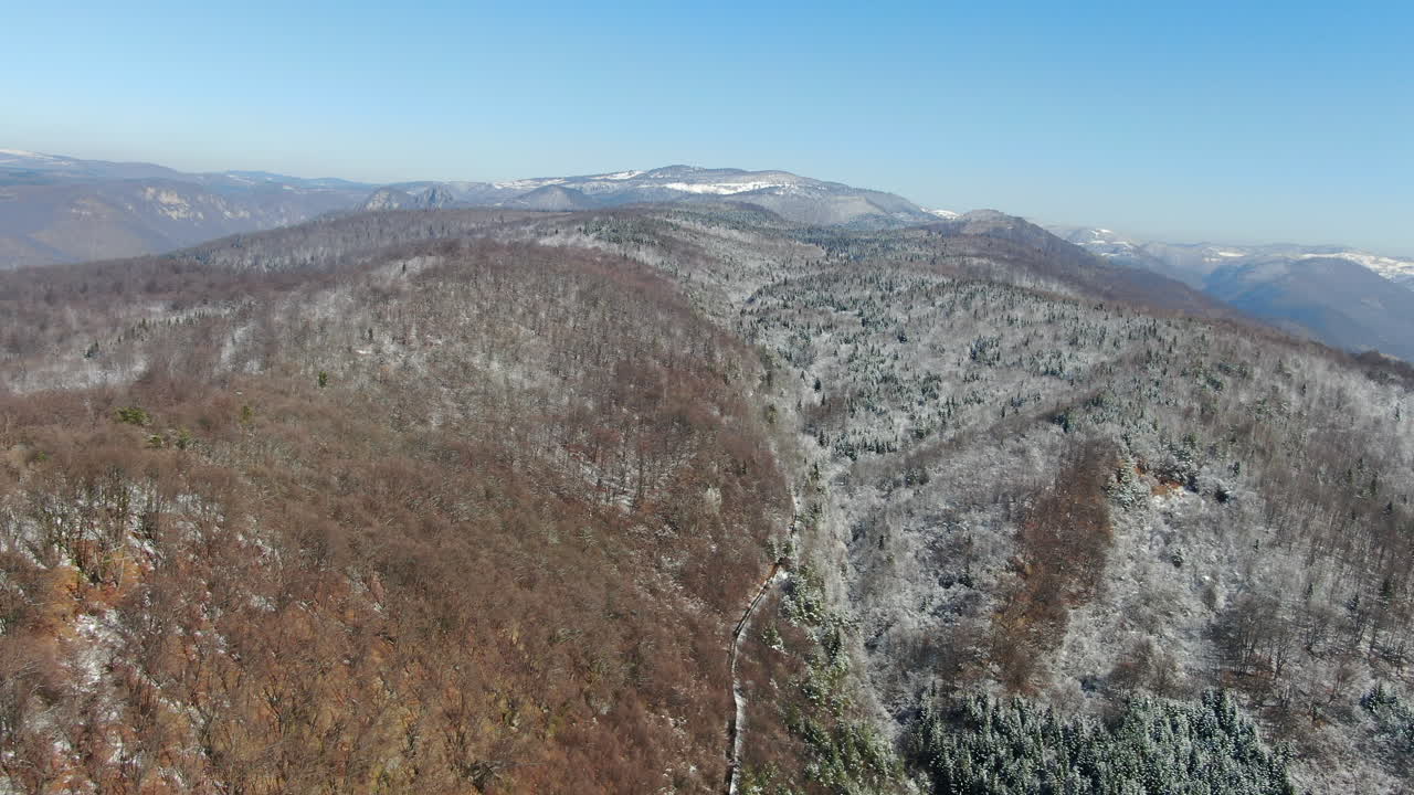 A landscape view of a mountain range covered in snow with a blue sky above captures the winter season scenery