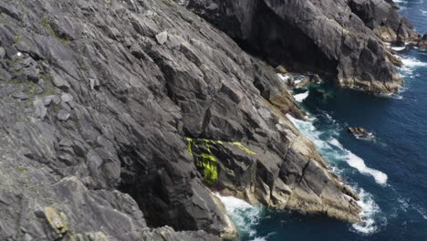 aerial - rocky, dangerous cliffs in dingle, county kerry, ireland, spinning shot