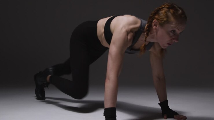 fotografía de estudio de una mujer madura con ropa de gimnasia haciendo ejercicio de escalador de montaña 3