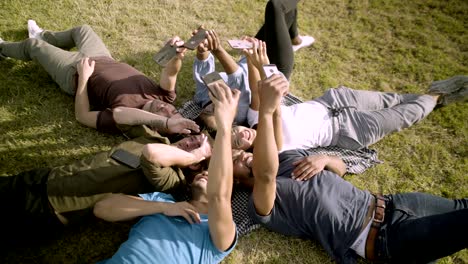 smiling young guys holding smartphones in outstretched arms.