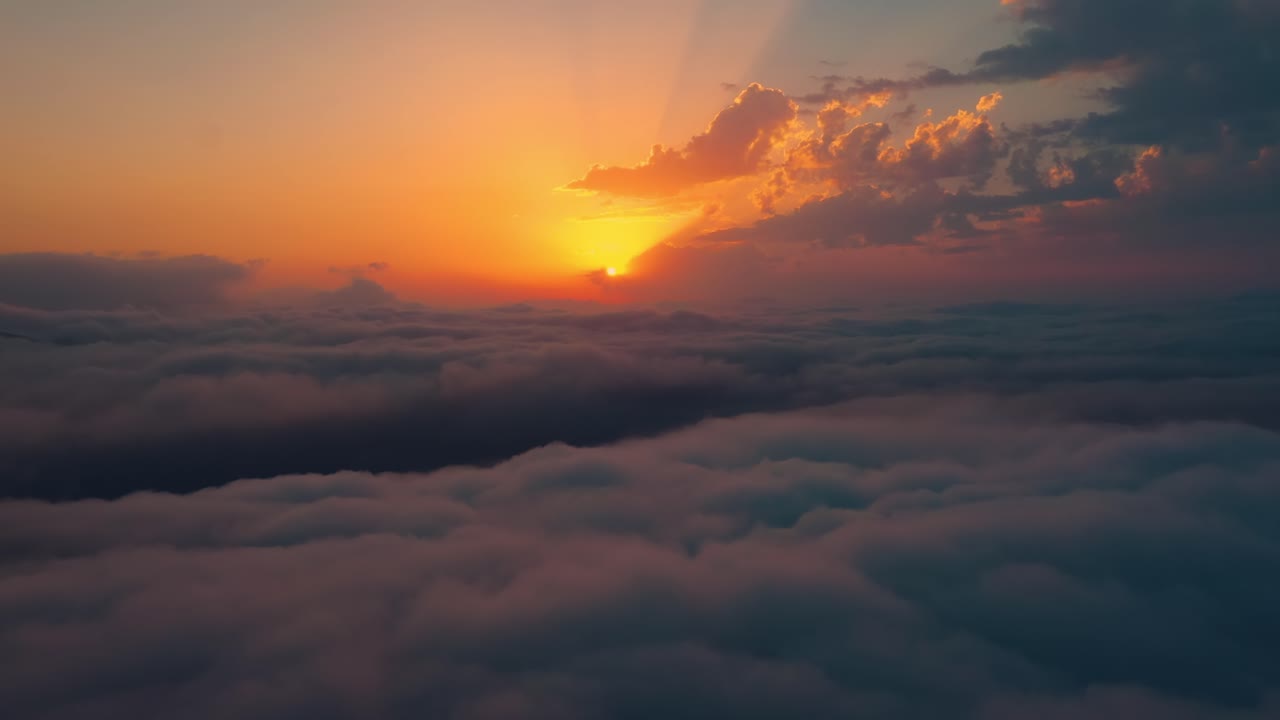 Flying over the clouds with the late sun. Sunrise or sunset colorful sky background.