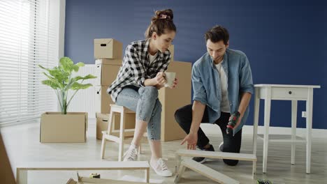 Tracking-right-video-of-couple-installing-bookshelf-in-new-house.