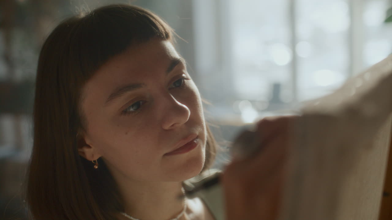 Young Female Artist Drawing on Canvas in Creative Studio