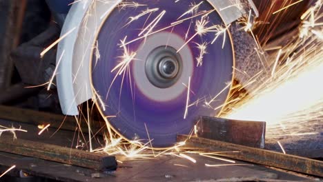 the worker cuts metal pipes with a grinder close-up. a lot of sparks.