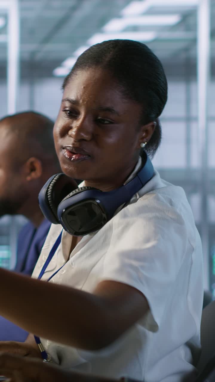 Video verticale: Lavoratore che aiuta un collega in un data center a monitorare le prestazioni