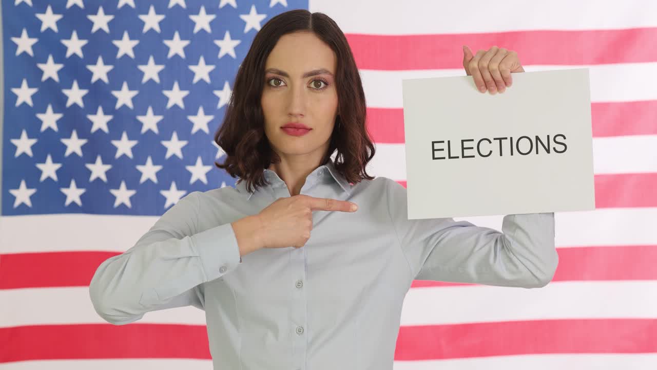 Woman holding 'Elections' sign in front of American flag