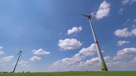 blue skies and white fluffy clouds above the green fields and wind turbines somewhere in germany