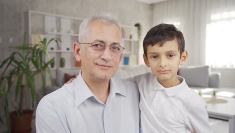 father and son looking at camera and smiling.