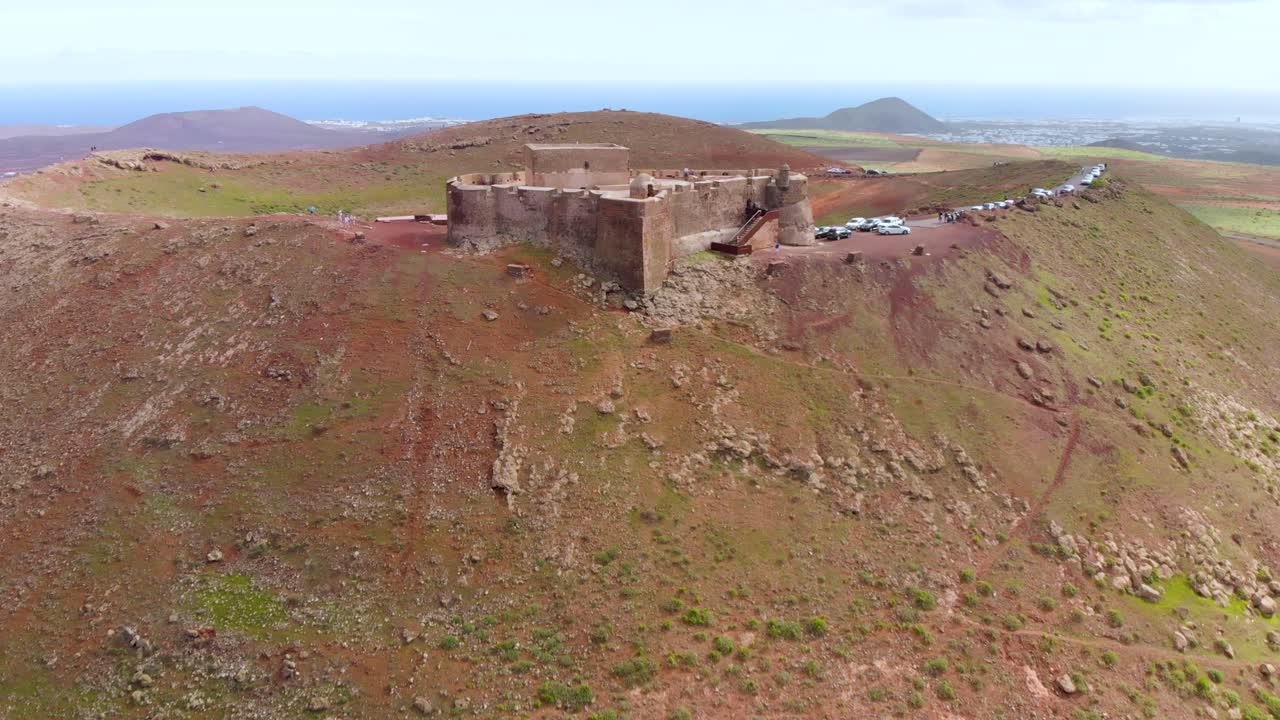 volando sobre un volcán con un antiguo castillo en su borde