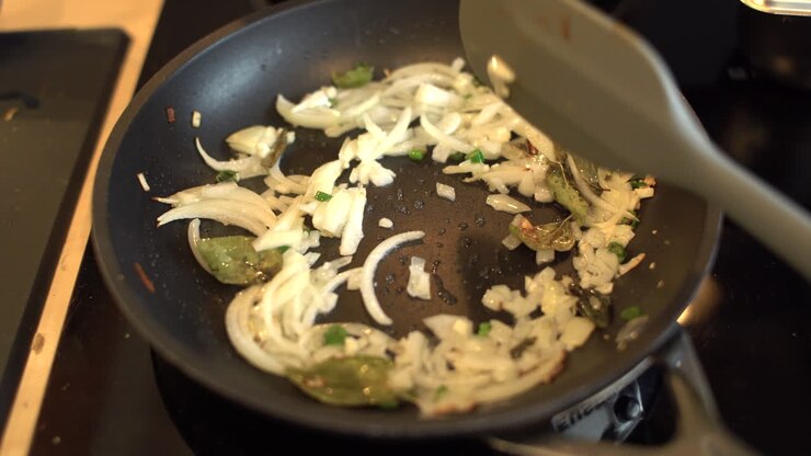 Close Up Shot of Female Hands Stirring Sliced White Onion
