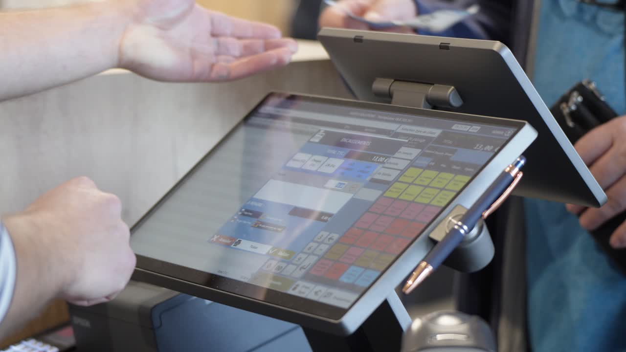 Cashier giving in price on the monitor while customer pays with cash.