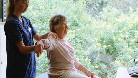 physiotherapist giving shoulder therapy to senior woman 4k