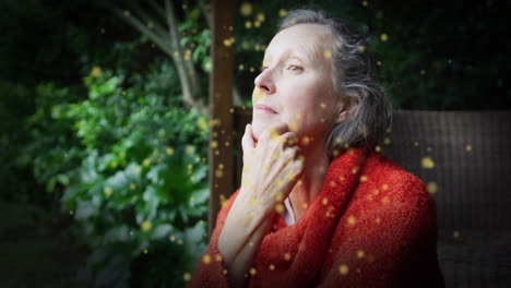 animation of green spots over thoughtful caucasian woman in garden