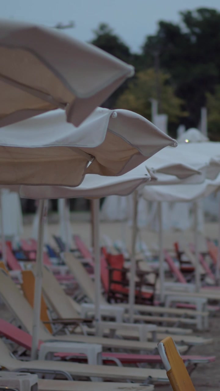 Chaise longue vuote in un resort in una sera nuvolosa e ventosa