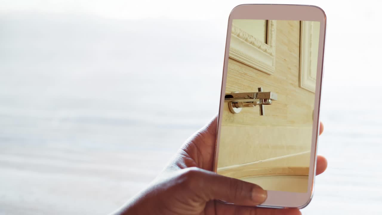 persona que sostiene un teléfono inteligente con interiores de baño modernos mostrados en la pantalla