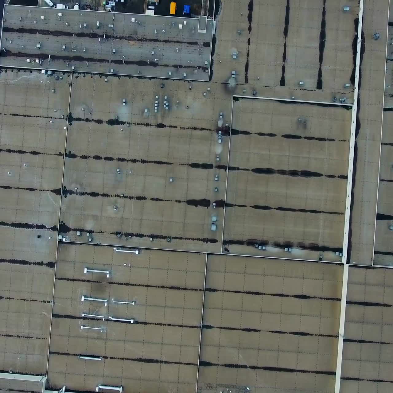 Gray roofs of huge modern factory. View from above on industrial territory