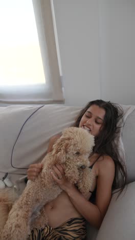 mujer y caniche en un sofá