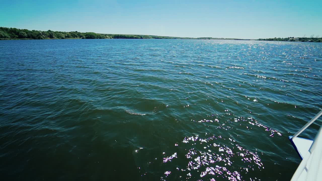 Shot of a boat bow cutting the ocean water with water splashes.