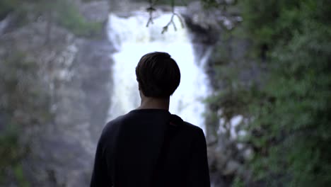 man die voor de waterval staat, mooi en geweldig uitzicht tijdens de wandeling