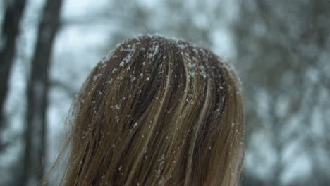 copos de nieve en cámara lenta caen en el cabello rojo de la mujer