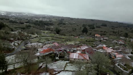 snowy village with vegetation in winter under a cloudy sky in picornio, a village in galicia