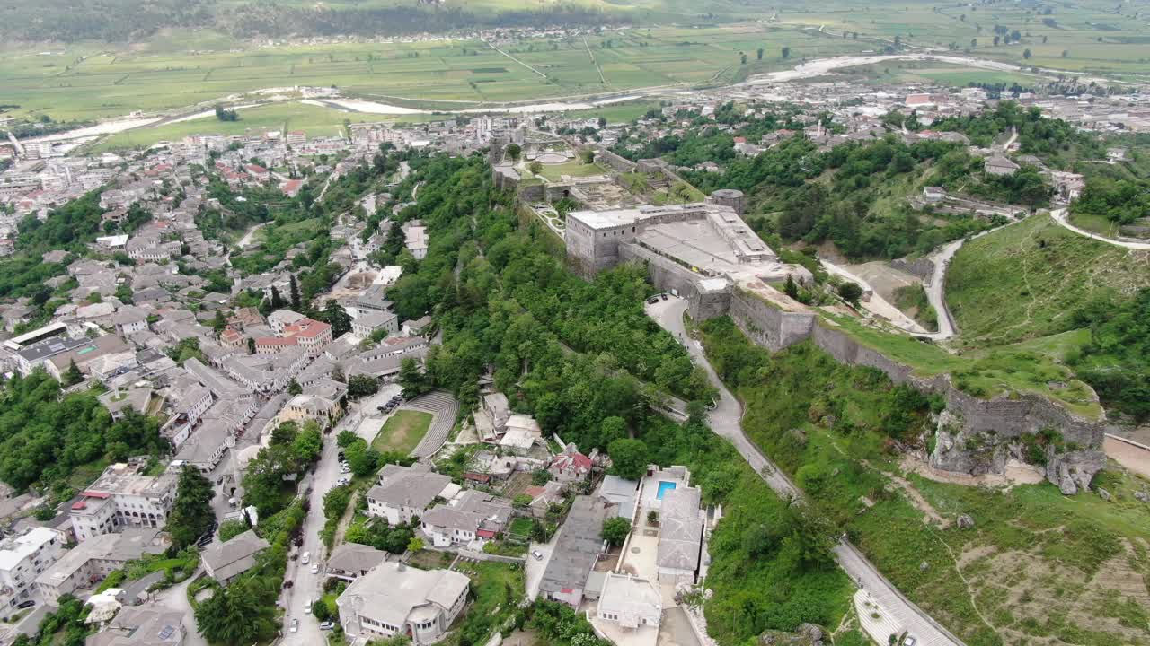 vista de avión no tripulado en albania volando en la ciudad de gjirokaster sobre un castillo medieval en terreno elevado vista lateral y superior